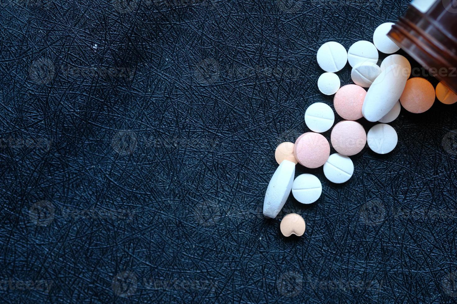 witte pillen morsen op zwarte achtergrond foto