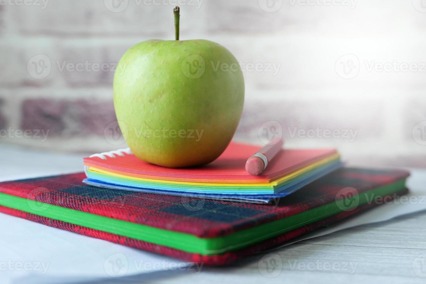 terug naar school-concept met appel op Kladblok op tafel foto