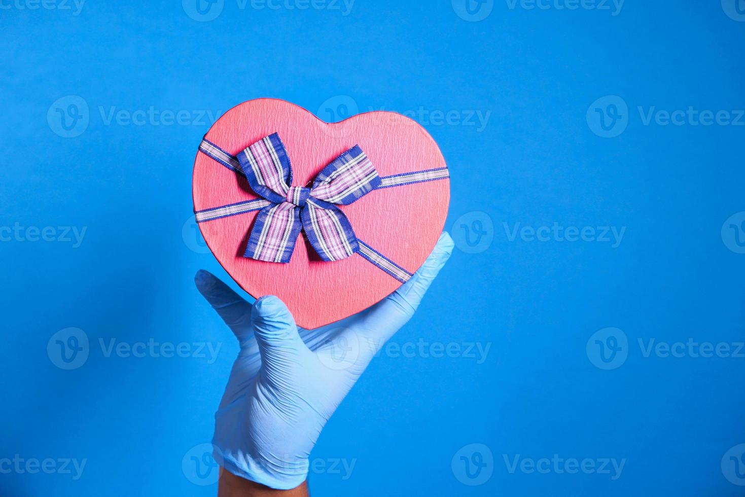 hand op rode hartvormige geschenkdoos foto