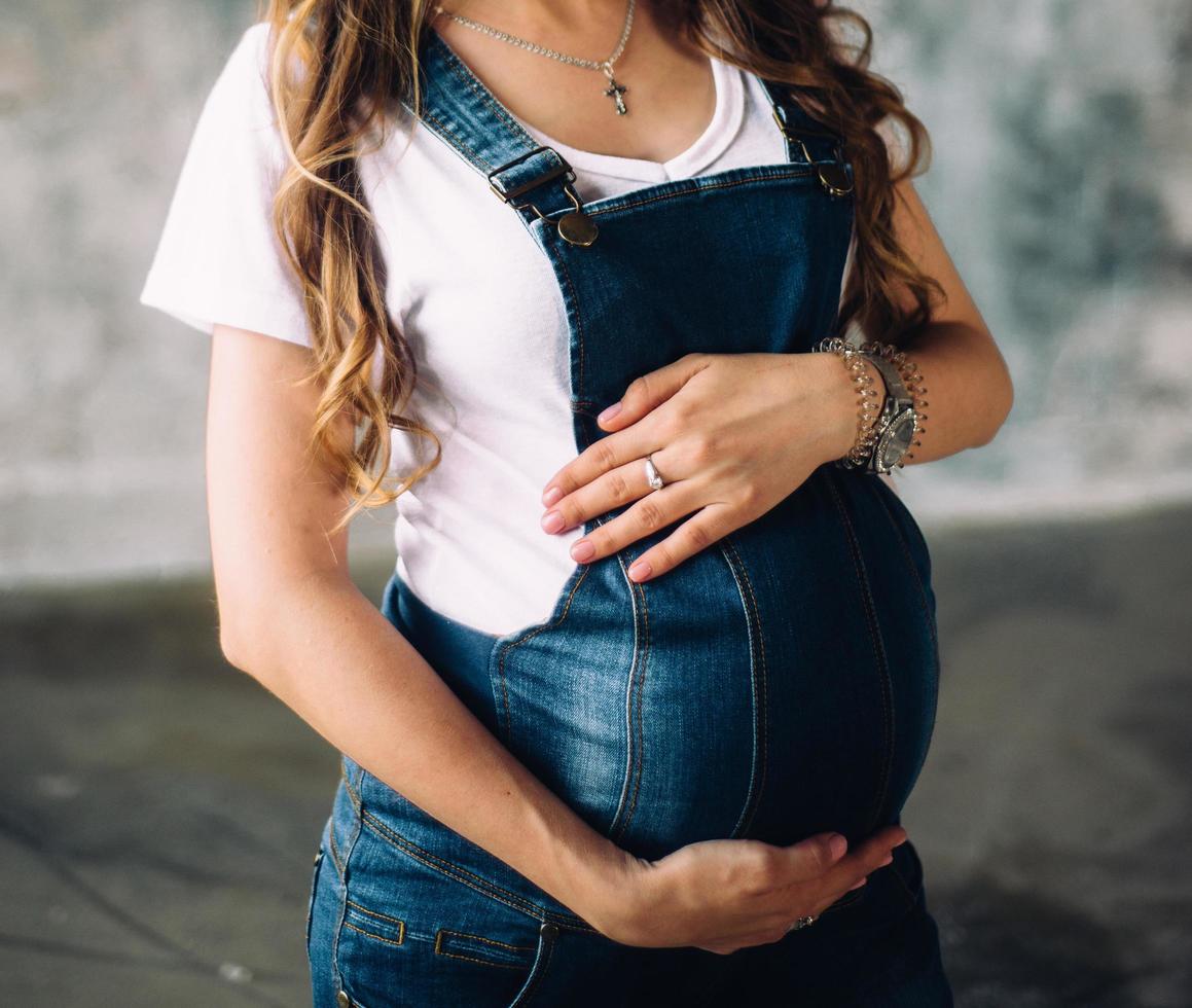 zwangere vrouw die haar buik houdt foto