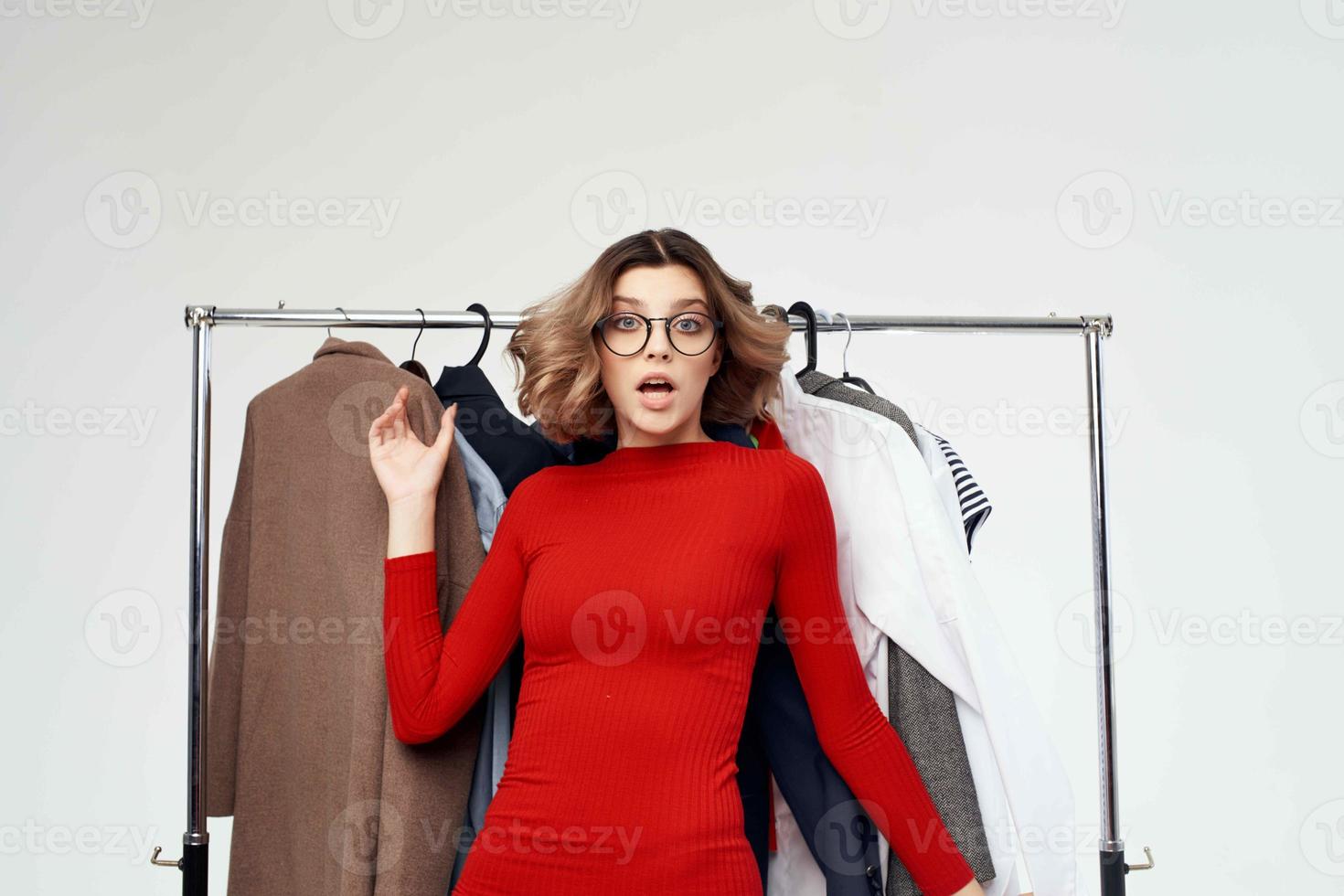 mooi vrouw in een rood jasje in de buurt de garderobe kleinhandel emoties foto