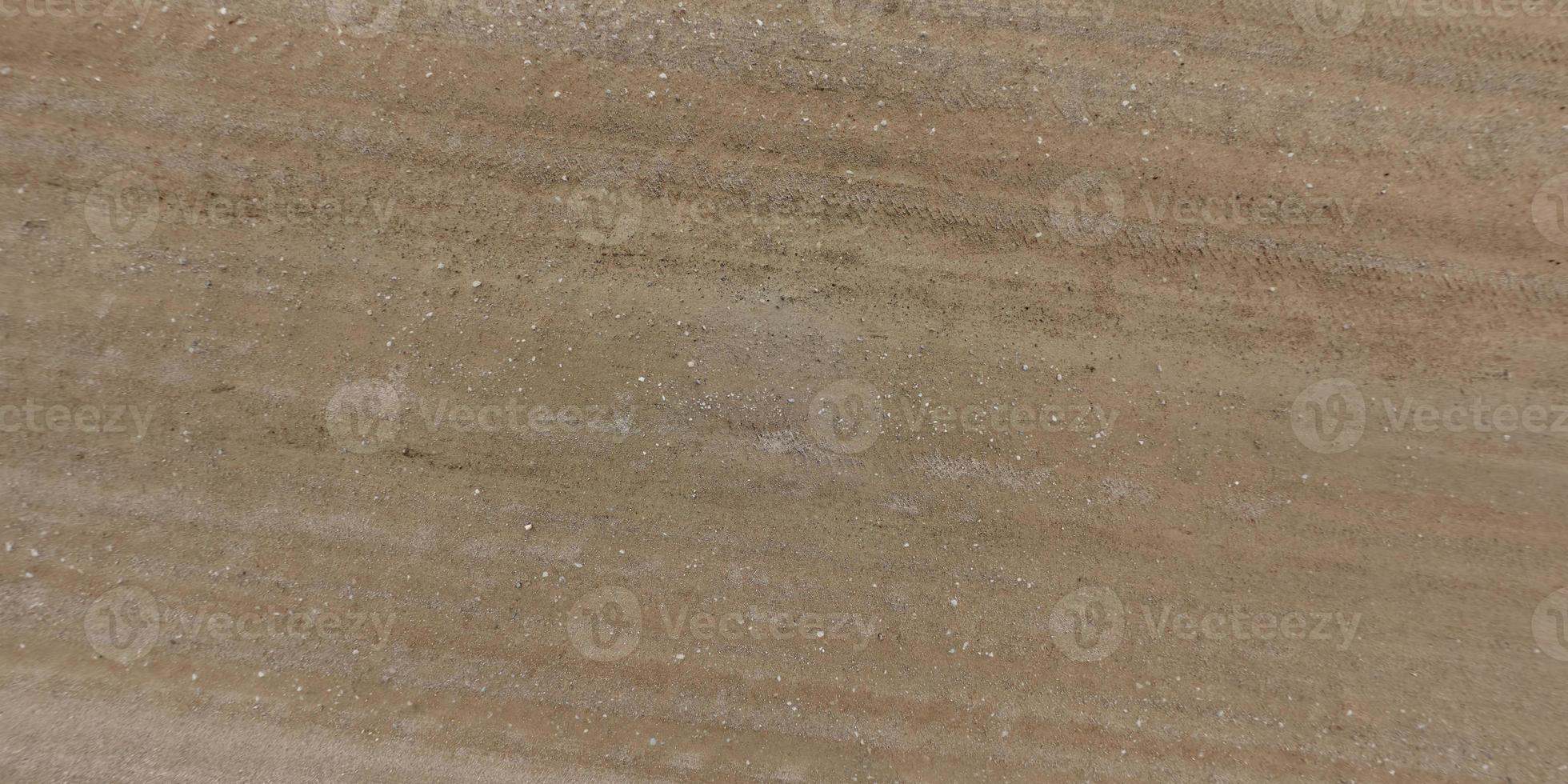 top visie van oppervlakte van grind weg gemaakt van klein stenen en zand met sporen van auto banden foto