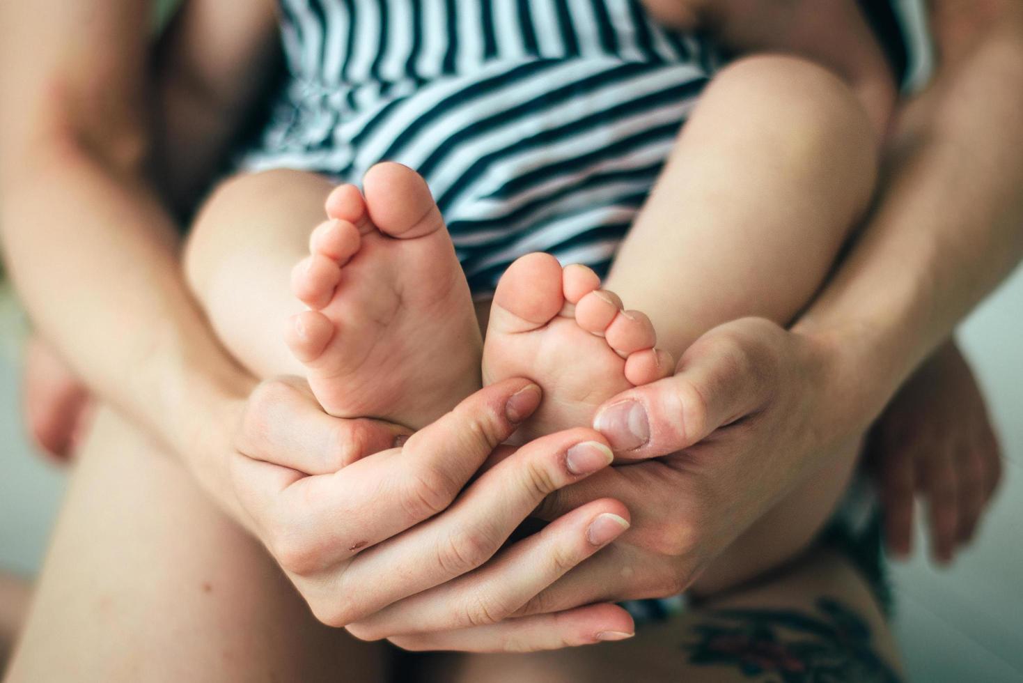 moeder die de voeten van het kind vasthoudt foto