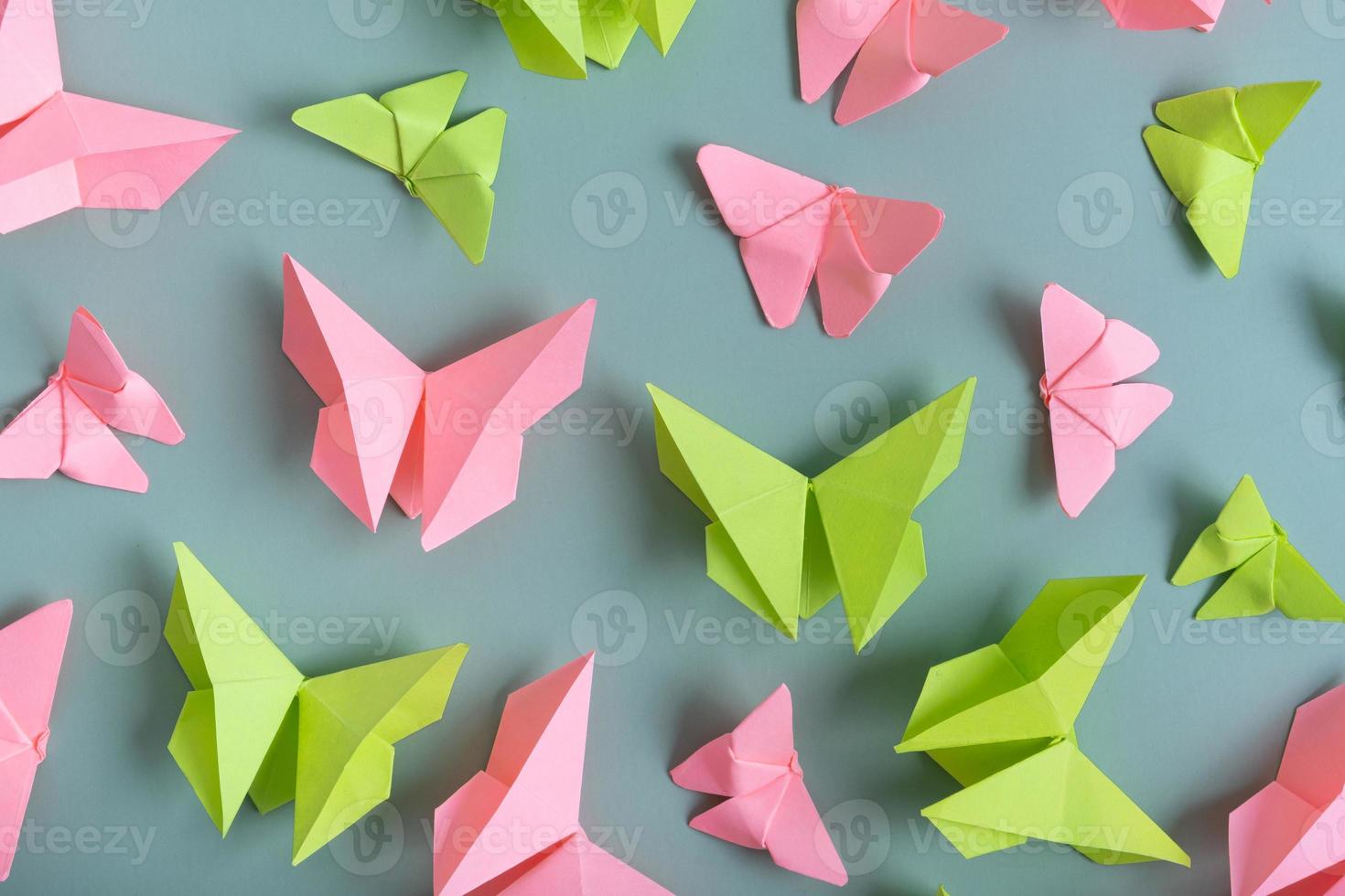 papier vlinders groen en roze kleur vlak leggen Aan een gekleurde achtergrond. lichtheid, voorjaar schoonheid concept foto