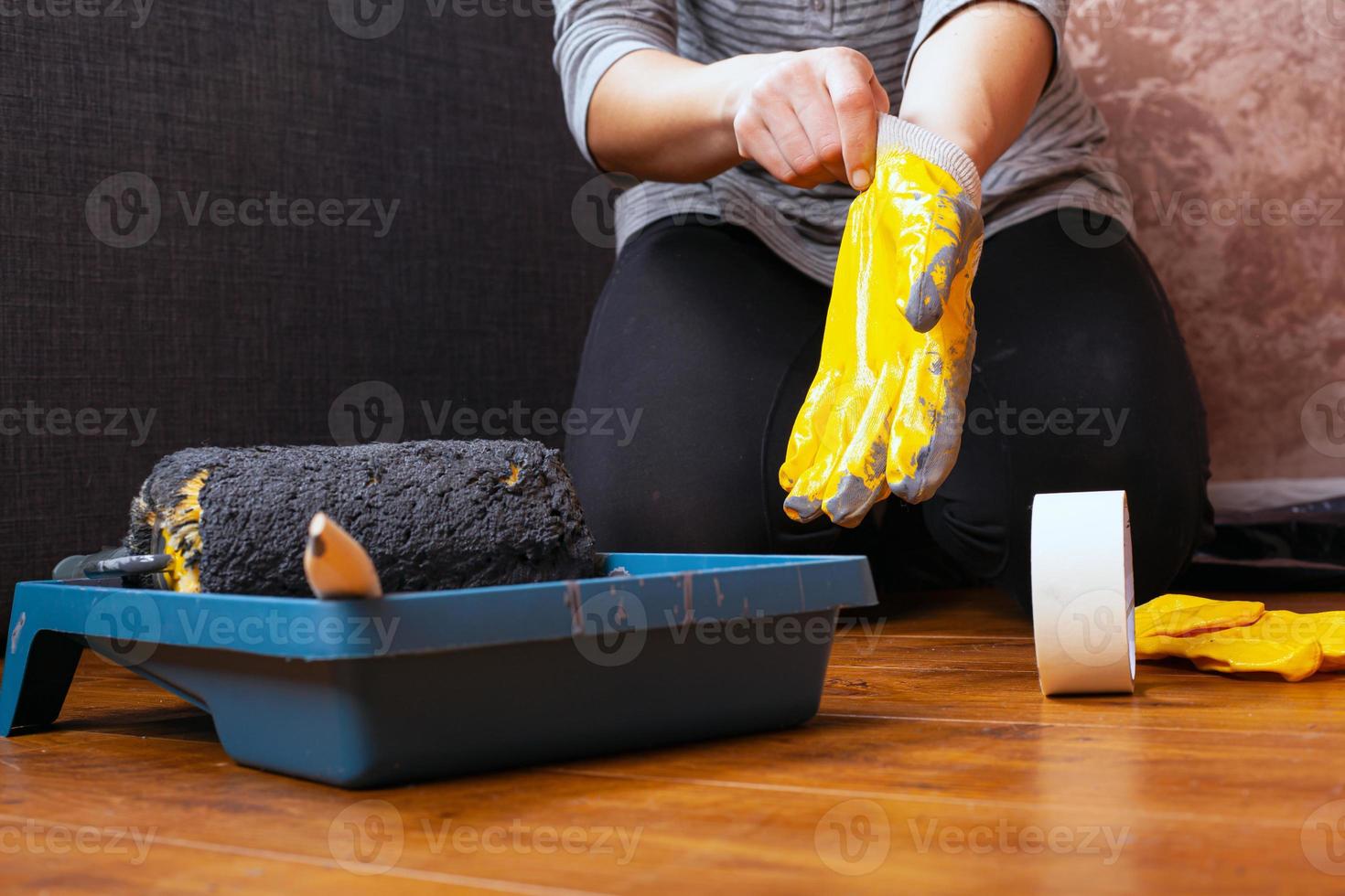 werkschilder trekt handschoenen aan. gereedschappen voor huisreparaties, muurschildering foto