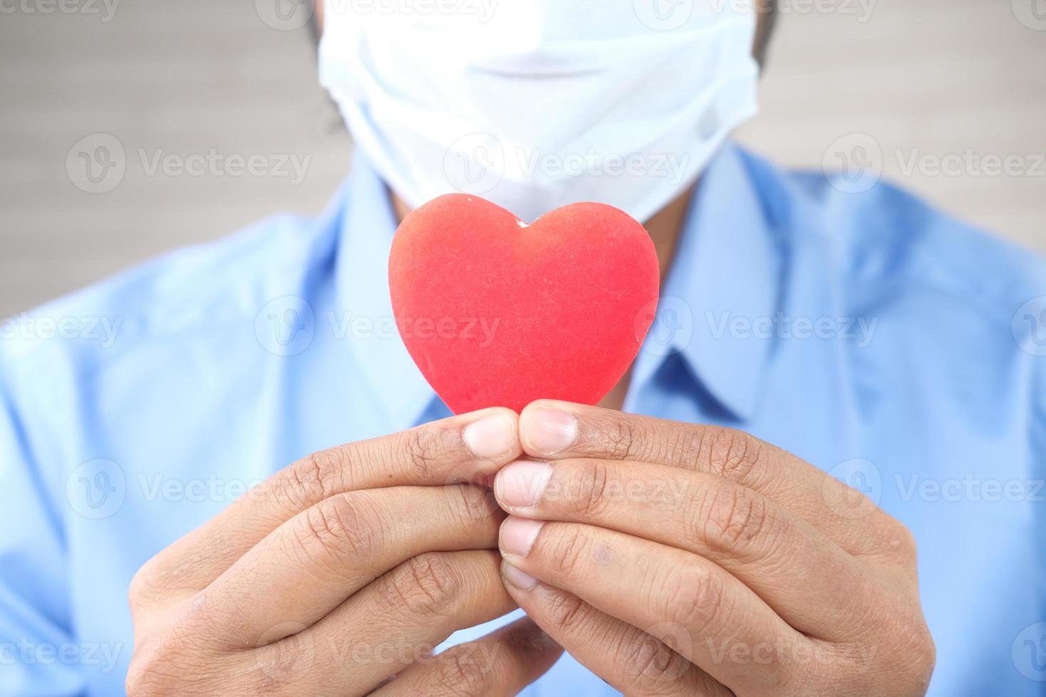 man in beschermend gezichtsmasker met rood hart met kopie ruimte foto