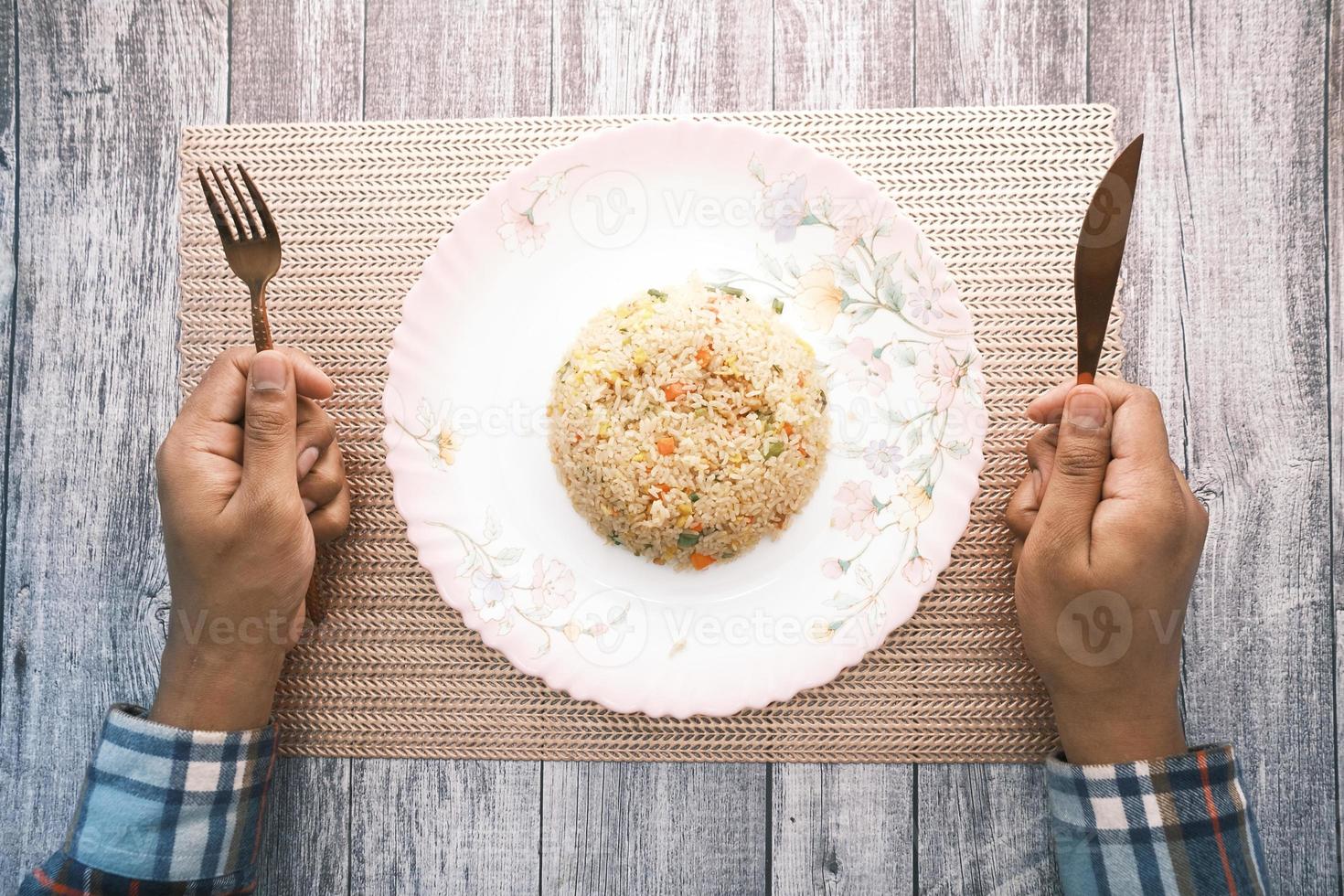 man met vork en mes gebakken rijst eten foto