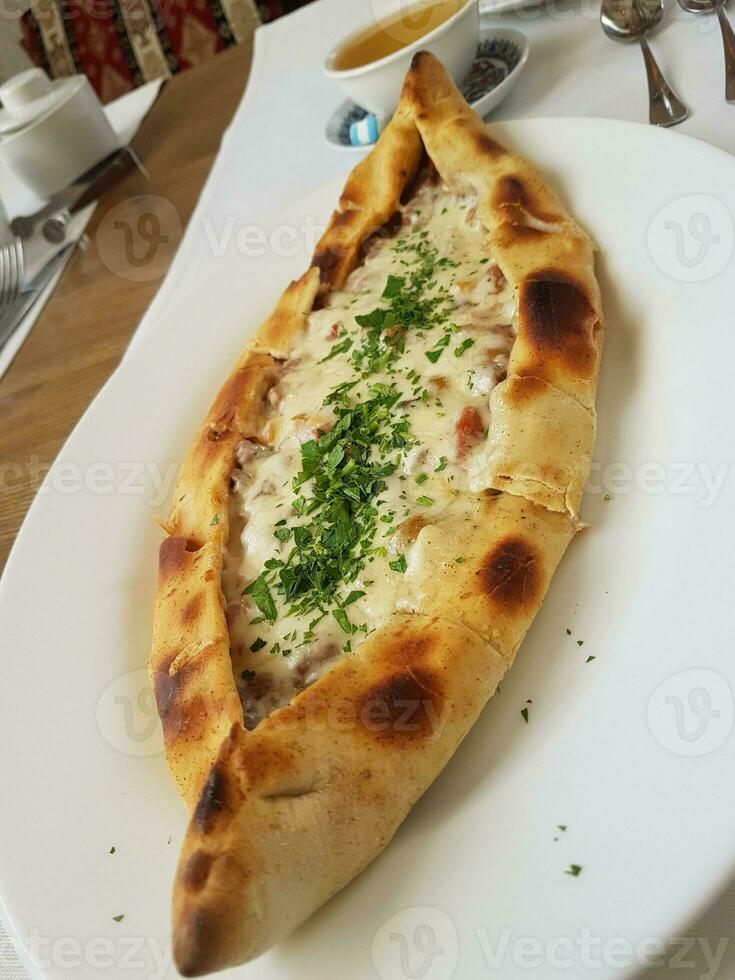 traditioneel Turks keuken kasarli pide bootvormig flatbread met kaas, specerijen en kruiden foto