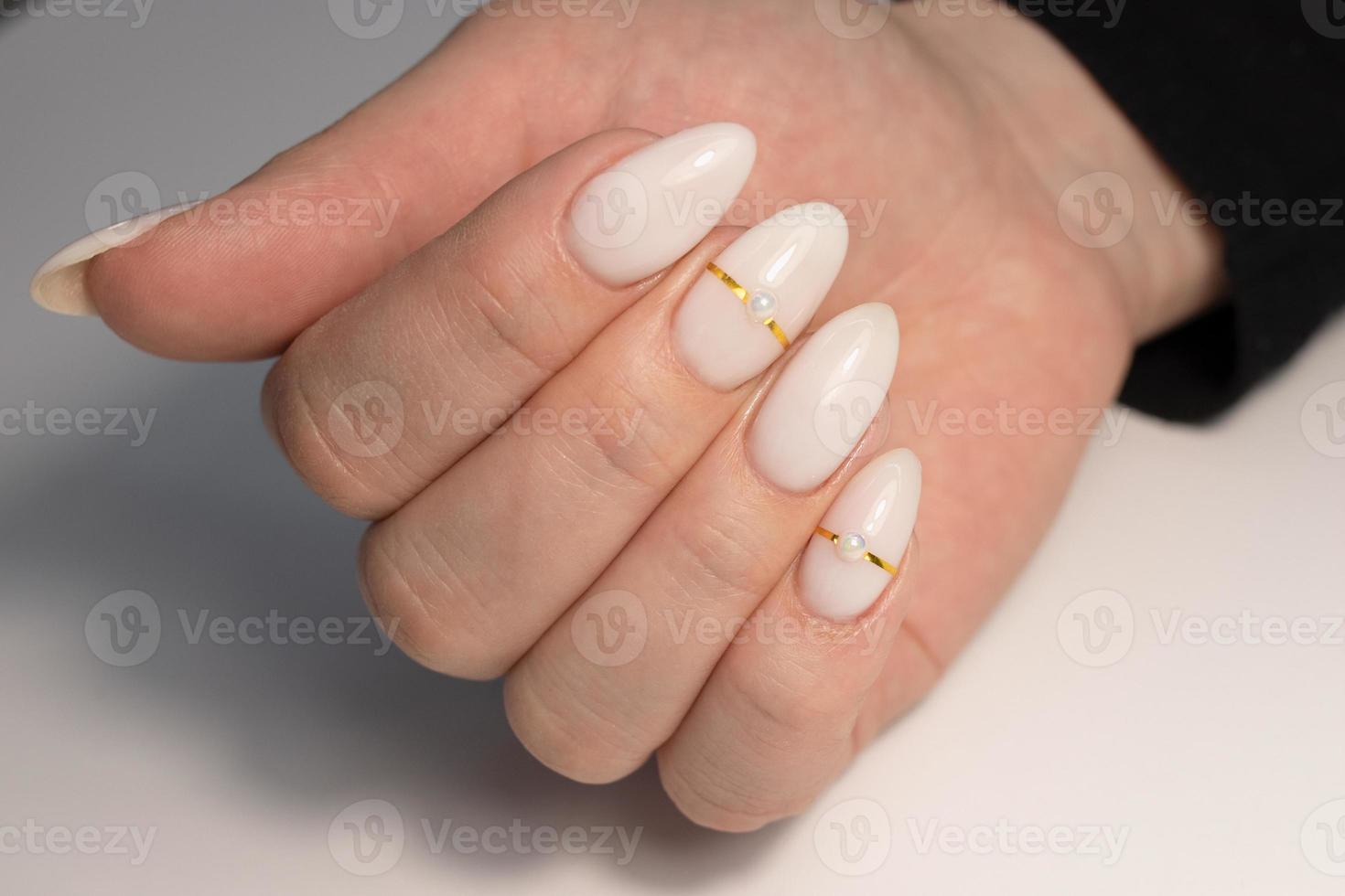 mooi naakt manicure met parels en goud strepen. manicure voor Dames met gel Pools. lang nagels in de vorm van amandelen foto