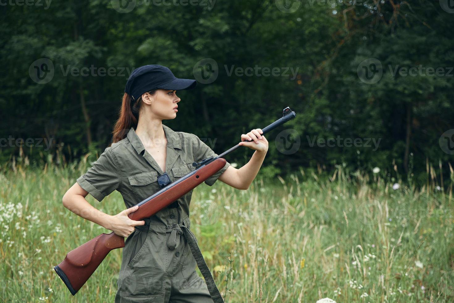 vrouw soldaat houdt een geweer in een kant visie tegen de achtergrond van de Woud foto