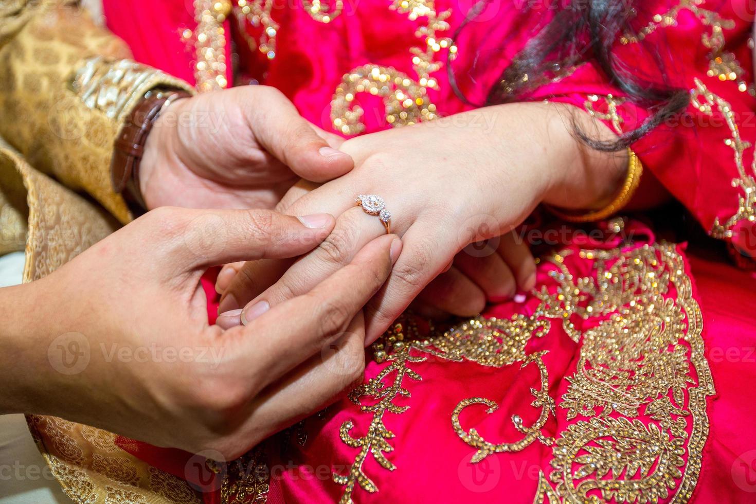 bruid plaatsen de bruiloft ring Aan de bruidegoms vinger Bij bangladesh. dichtbij omhoog afbeelding. foto