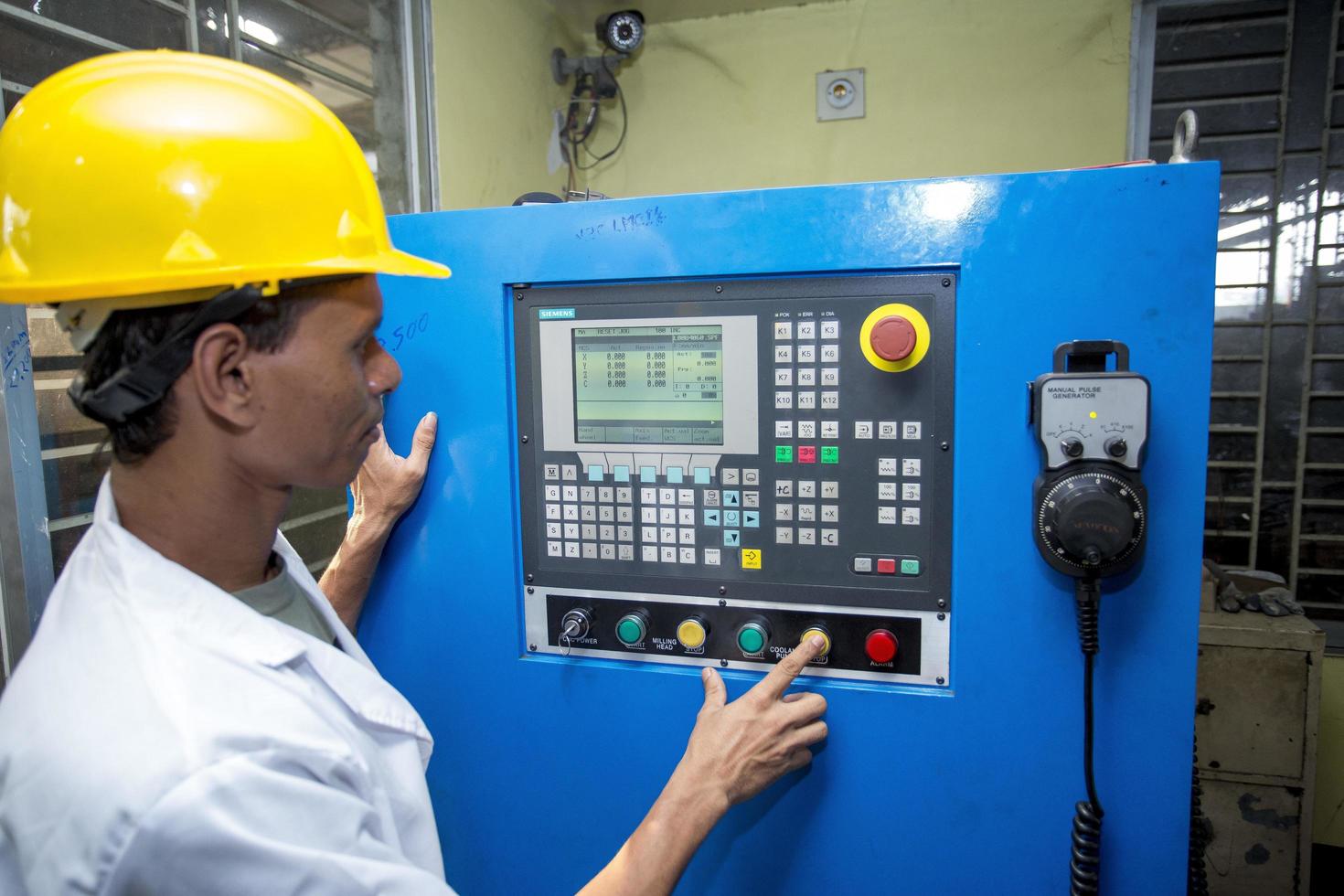Bangladesh mei 20, 2015 een fabriek laboratorium operator gebruik makend van staal hengel kwaliteit testen machine Bij hoera, dhaka, bangladesh. foto