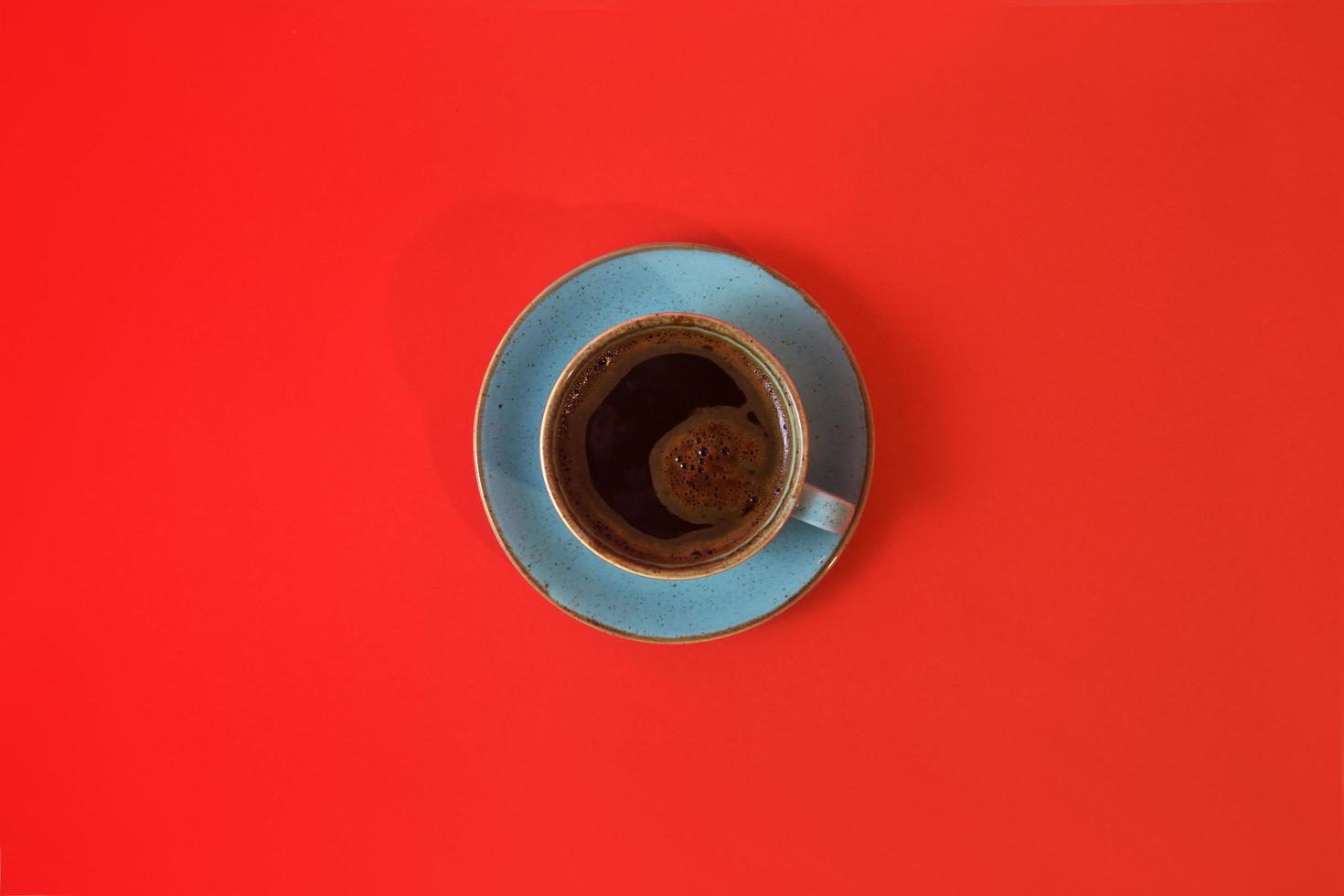 koffiekopje geïsoleerd op rode achtergrond met kopie ruimte. bovenaanzicht van sterke koffie in de ochtend. foto