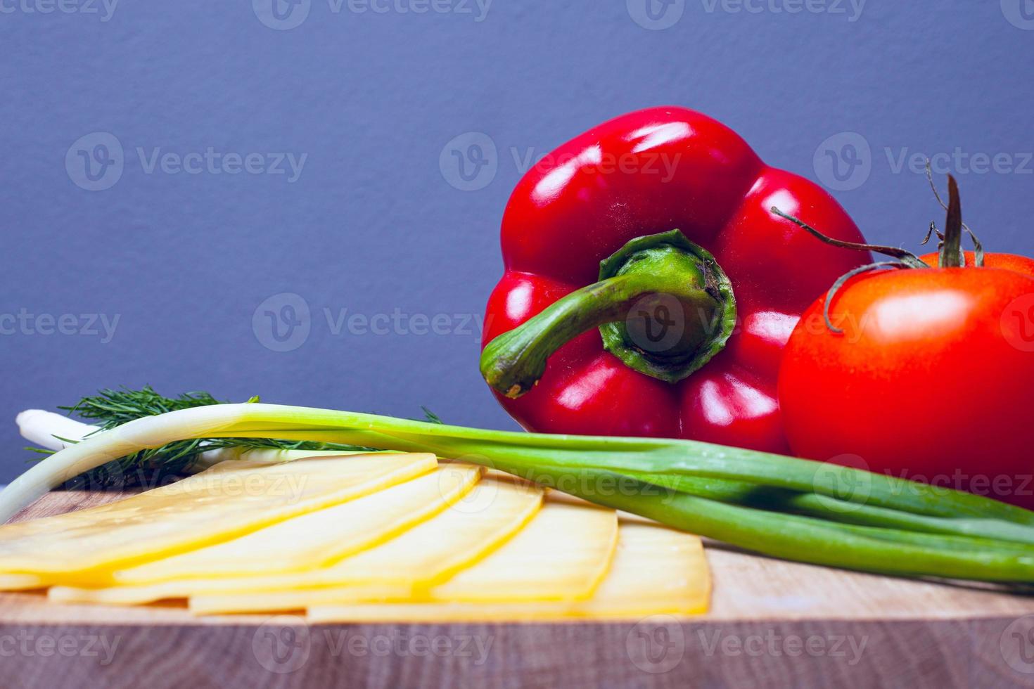 groenten met kruiden en kaas op een houten standaard op een grijze achtergrond foto