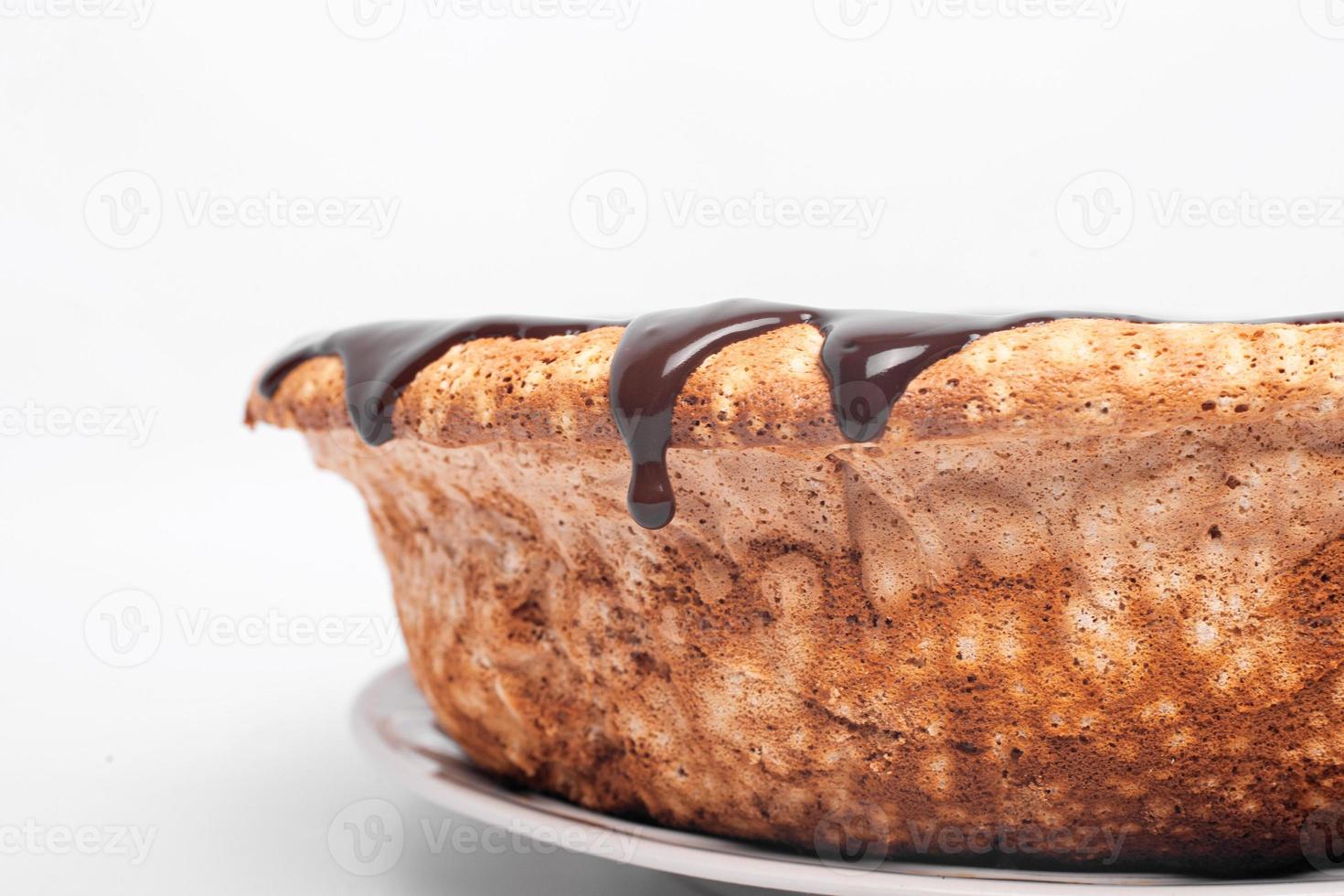 stromende chocolade aan de zijkanten van de cake op witte achtergrond foto