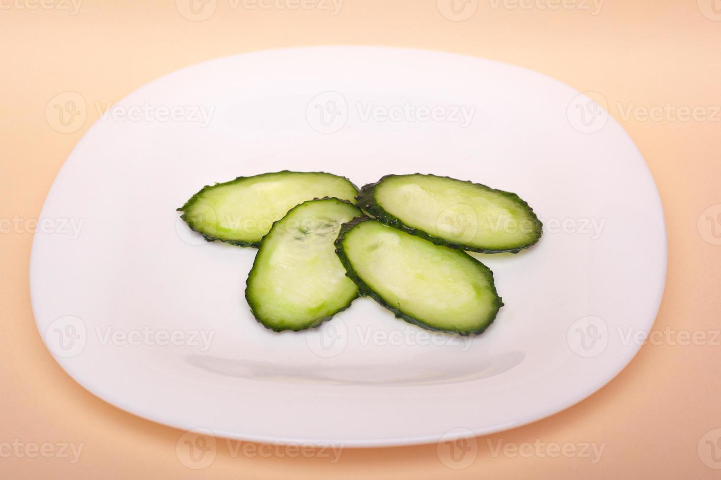 gesneden verse komkommers op een witte plaat foto