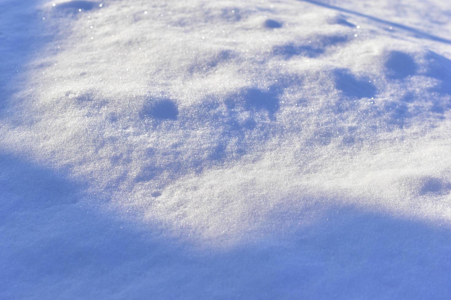 besneeuwde ondergrond in de winter met schaduwen in de avond foto