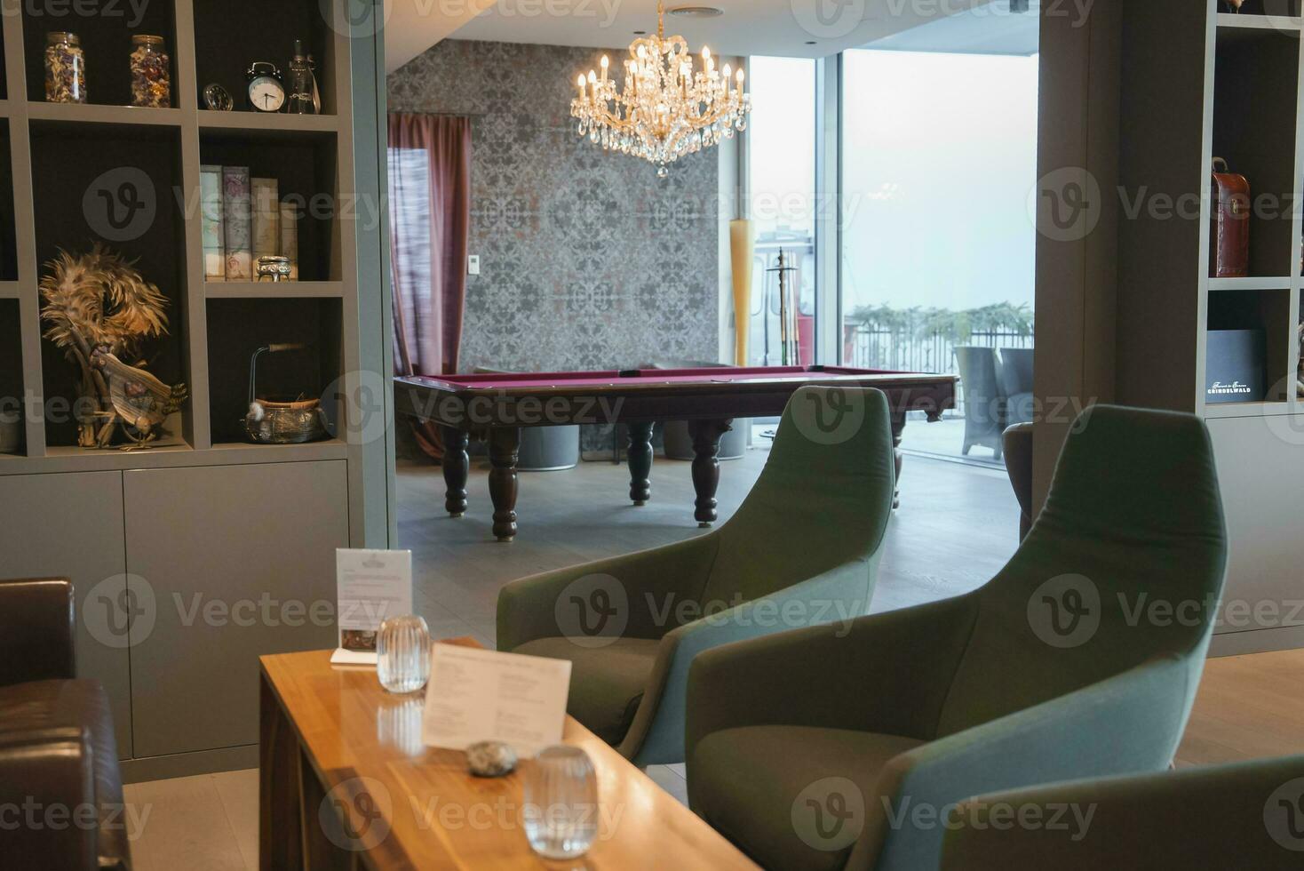 stoelen met verlichte kroonluchter over- snooker tafel in achtergrond foto