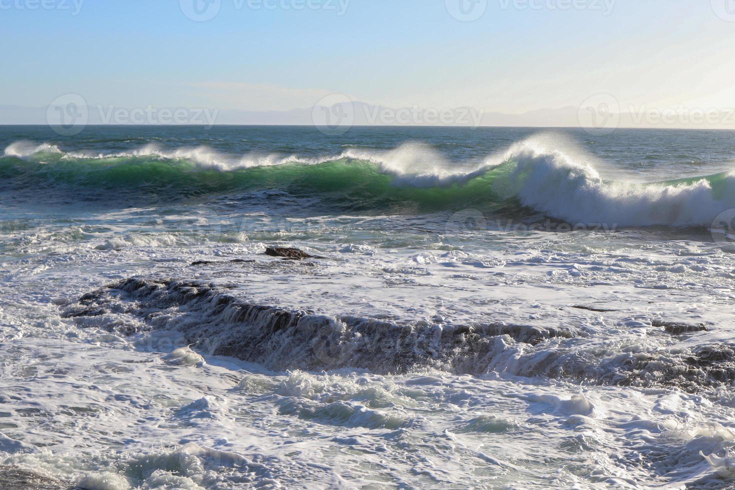 groot golven rollend in Aan de rotsachtig kust foto