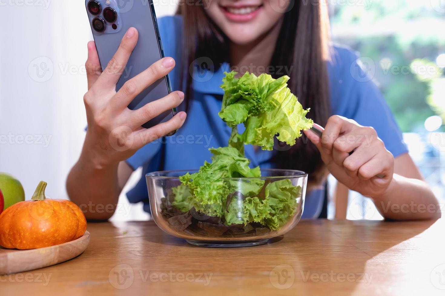 eetpatroon, witte huid jong Aziatisch vrouw in een blauw overhemd aan het eten groente salade en appels net zo een gezond eetpatroon, kiezen voor rommel voedsel. vrouw voedingsdeskundige verliezende gewicht. gezond aan het eten concept. foto