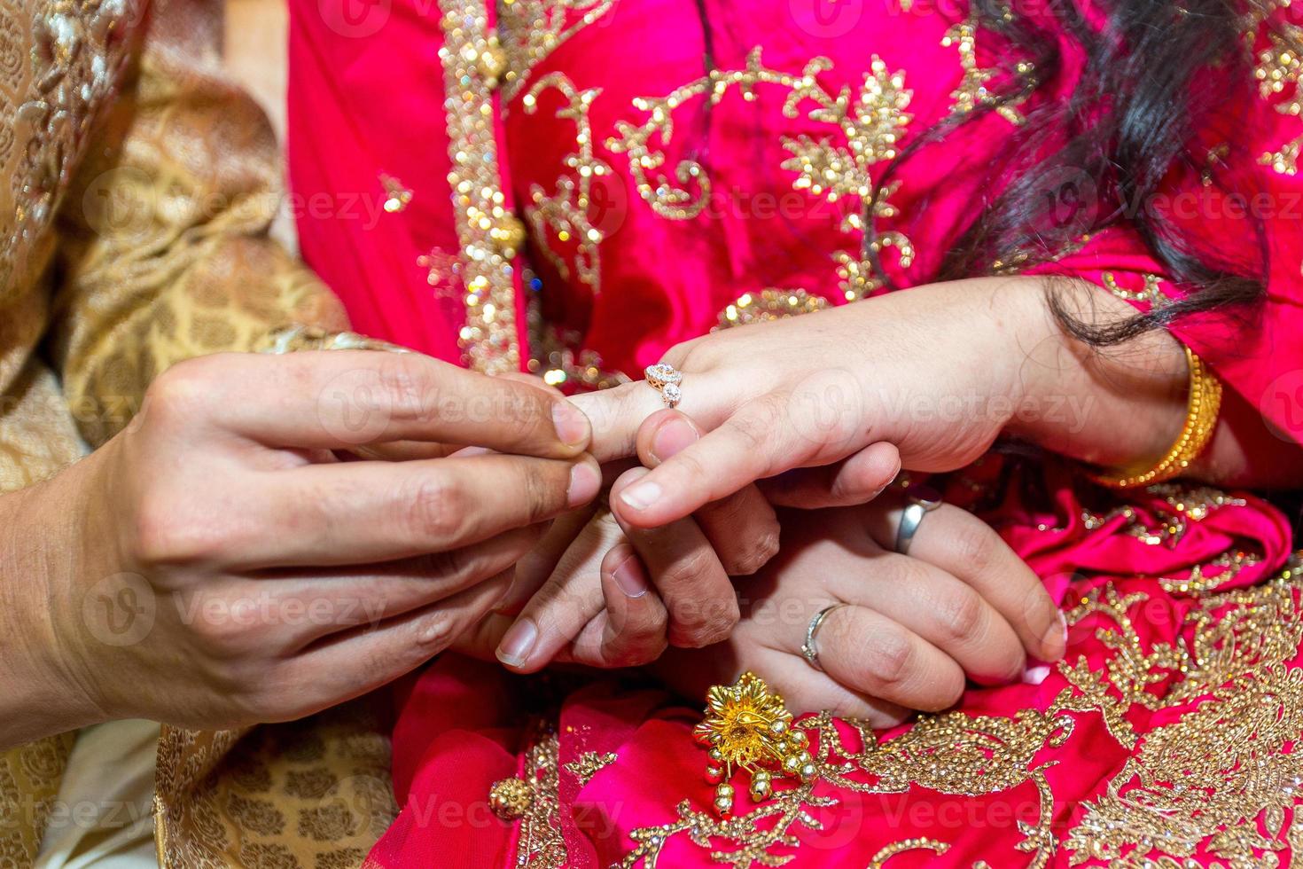 bruid plaatsen de bruiloft ring Aan de bruidegoms vinger Bij bangladesh. dichtbij omhoog afbeelding. foto