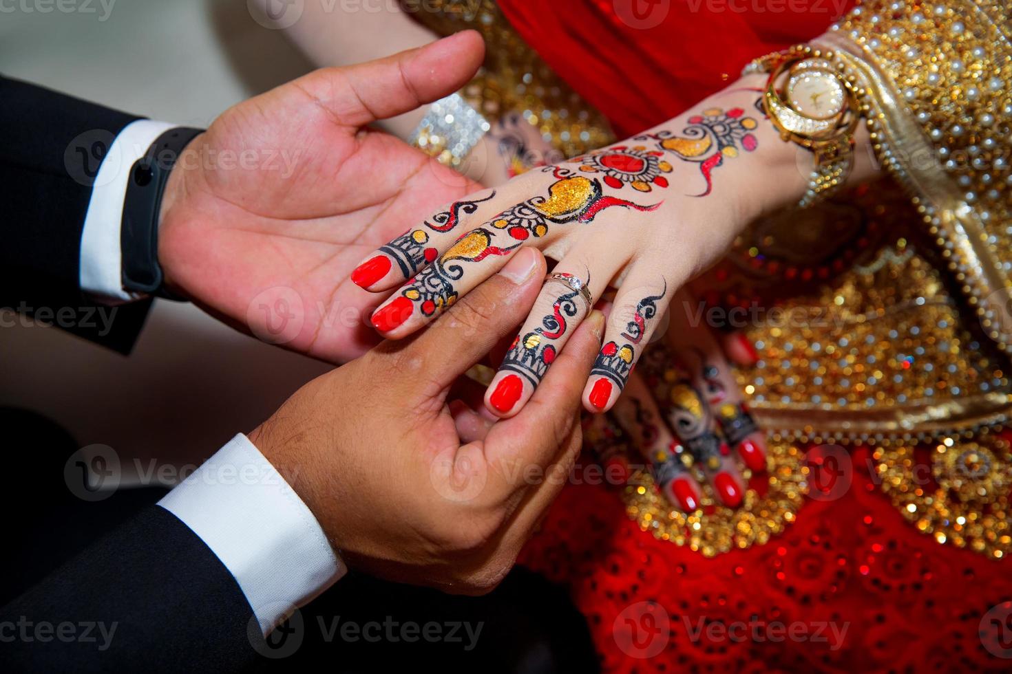 een bruidegom zet de ring Aan de vinger van bruid. Indisch bruiloft. foto