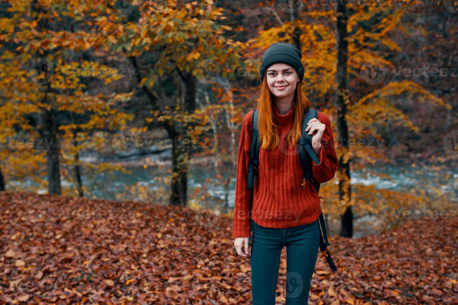 herfst park gedaald bladeren hoog bomen rivier- in de achtergrond en vrouw reizen toerisme foto