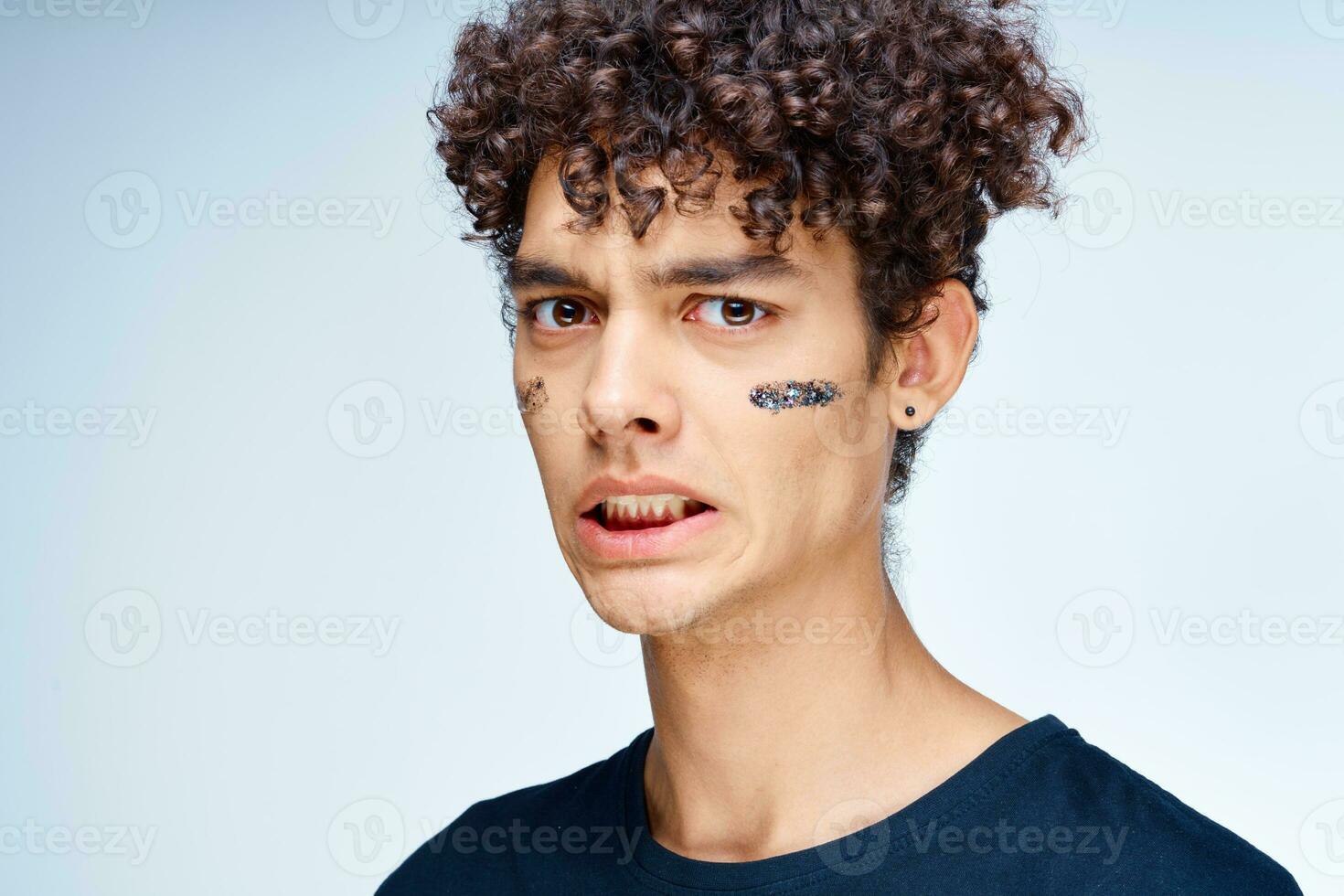 vent met gekruld haar- is van toepassing een zwart masker Aan zijn gezicht schoonheidsspecialiste foto