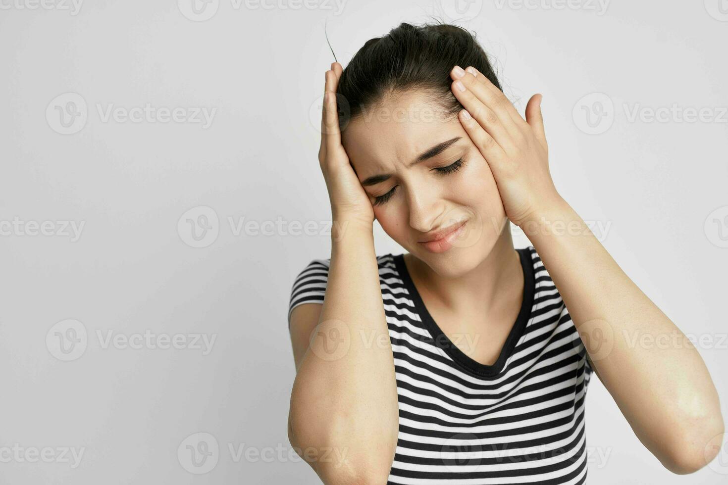 brunette in een gestreept t-shirt pijn in de nek geïsoleerd achtergrond foto