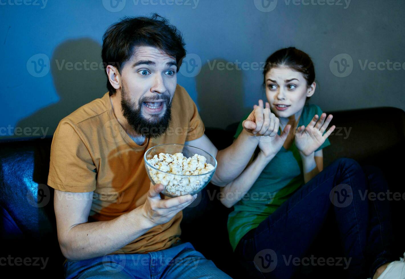 vrienden Mens en vrouw aan het kijken TV Aan de bankstel en popcorn in een bord foto