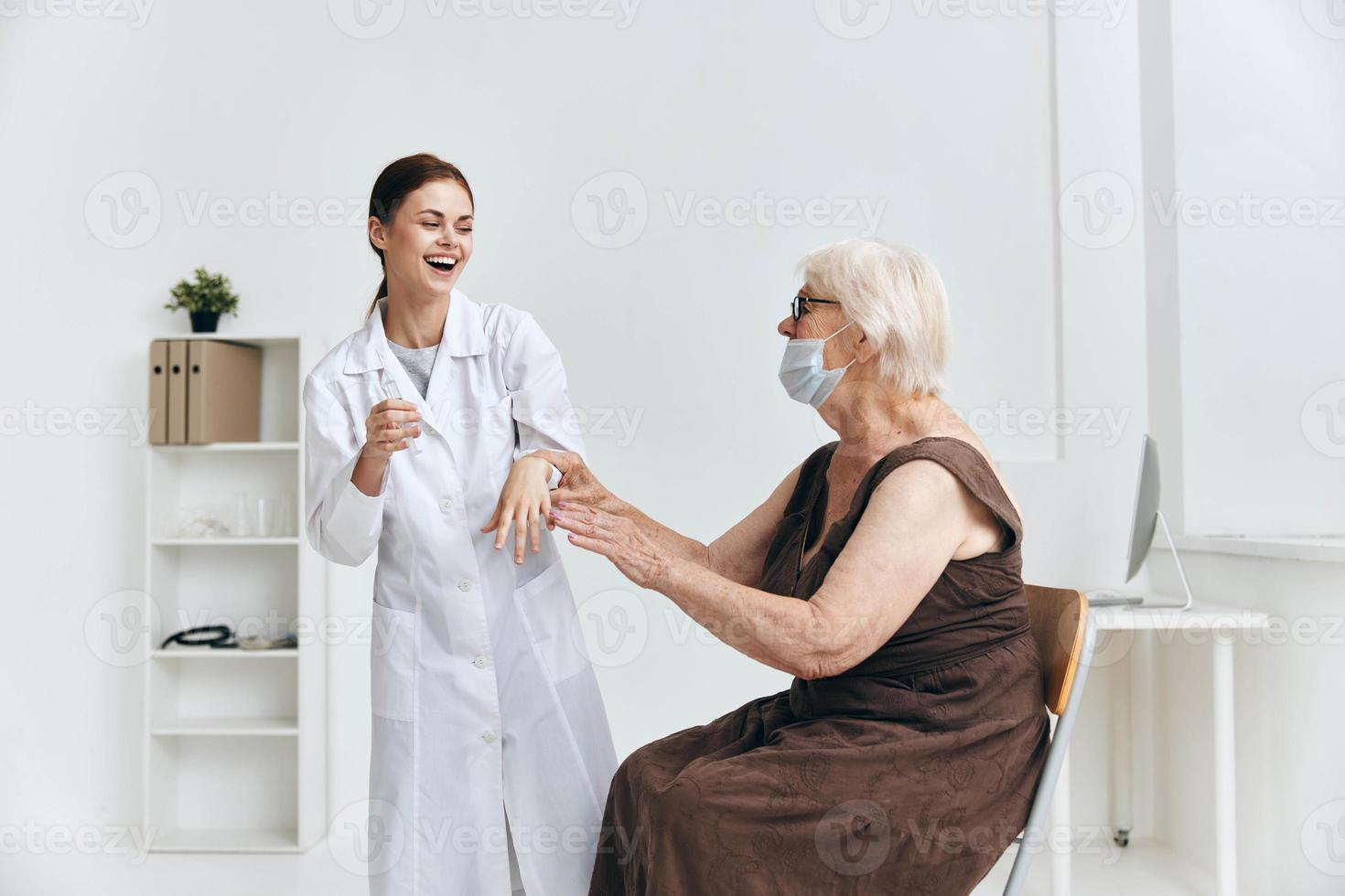 verpleegster geven injectie naar een ouderen vrouw met een injectiespuit ziekenhuis foto