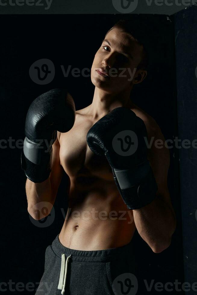 atleet in boksen handschoenen Aan zwart achtergrond portret bijgesneden visie foto