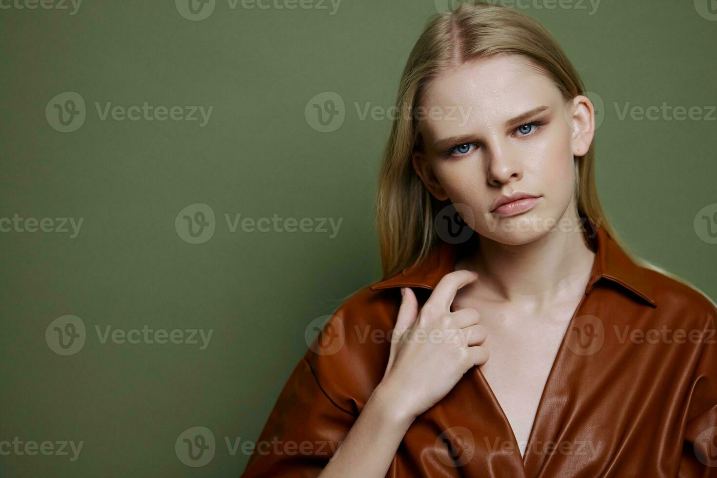 mode aanbod voor banier ontwerp. detailopname portret van zelfverzekerd jong vrouw aanraken leer loopgraaf jas looks Bij camera Bij olijf- groen studio muur achtergrond foto