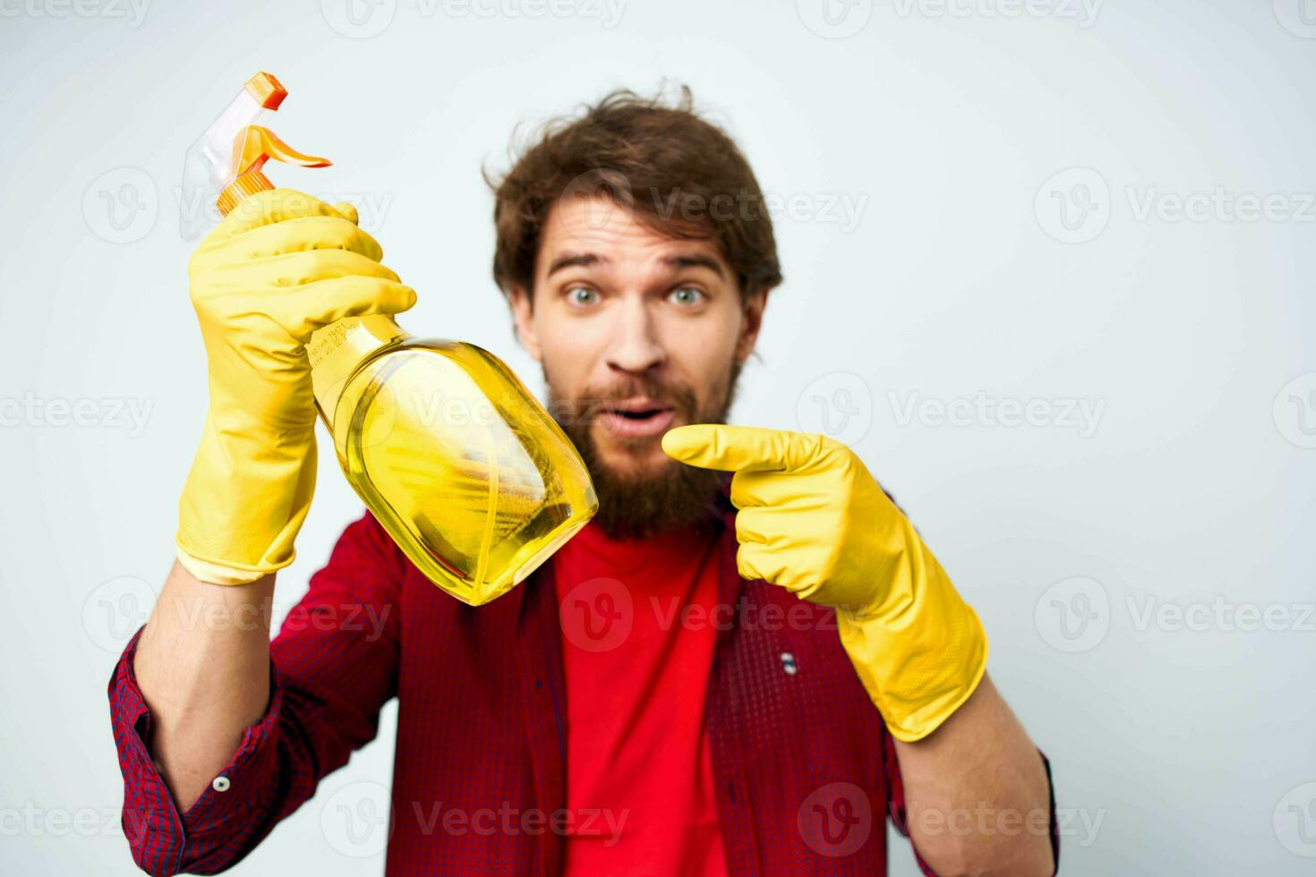 Mens in rubber handschoenen wasmiddel emoties rood overhemd huiswerk foto