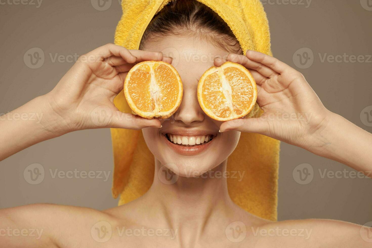 vrolijk vrouw Holding sinaasappels in de buurt haar ogen huid zorg foto