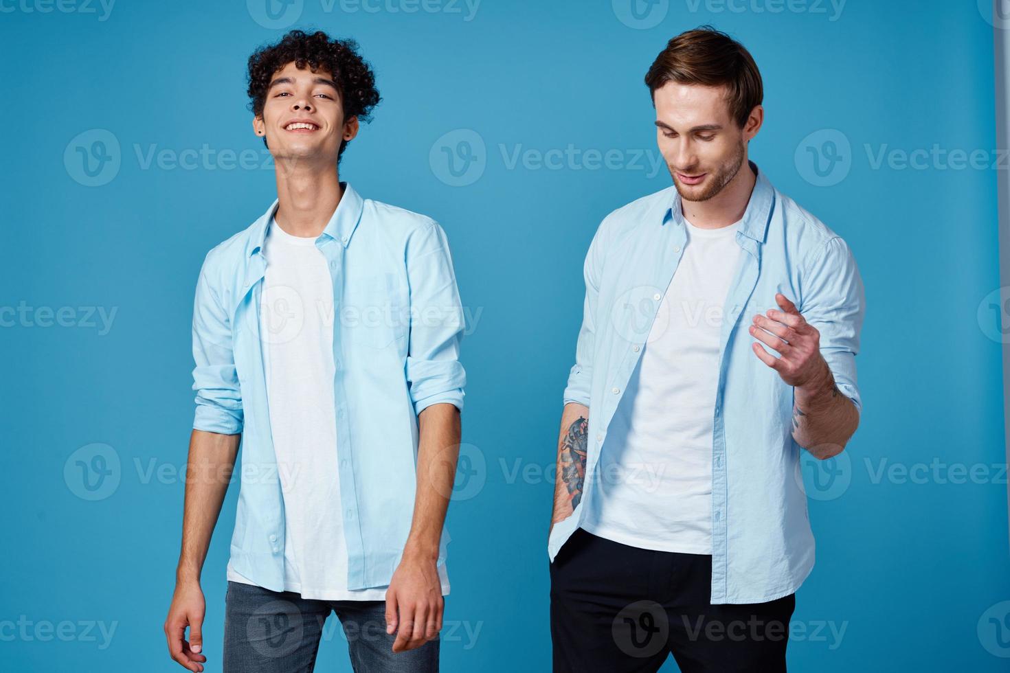 vrienden in identiek kleren Aan blauw achtergrond gebaren met handen bijgesneden visie foto