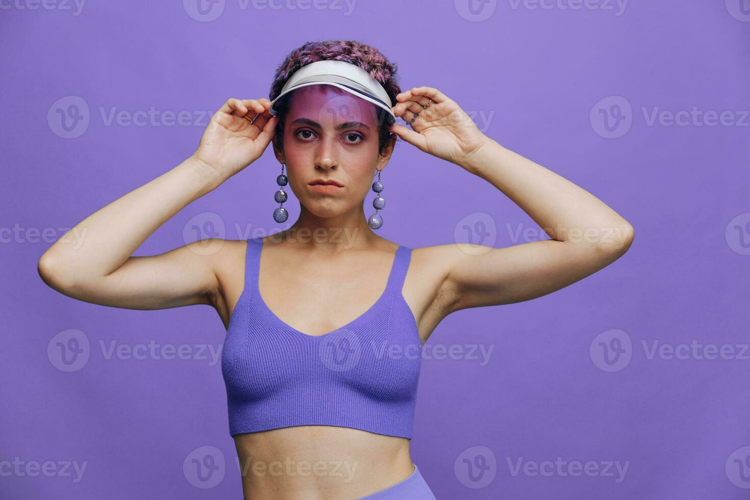 portret van een sportief mode vrouw poseren in een Purper sport- pak voor yoga en een transparant pet Aan een Purper achtergrond monochroom foto