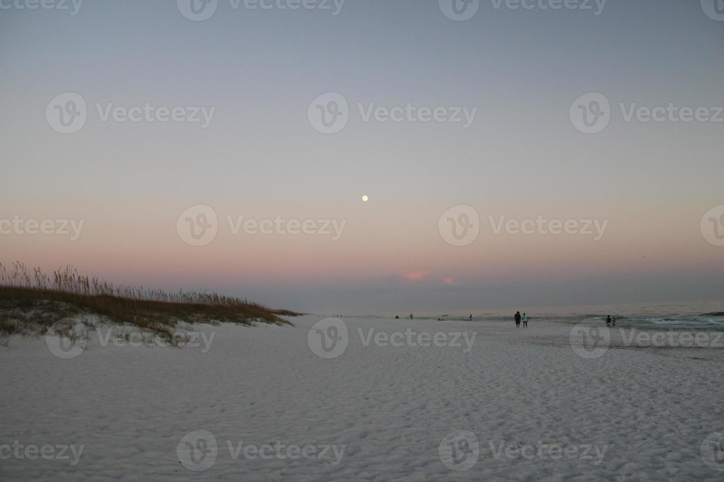 maan in grijs lucht van de strand foto