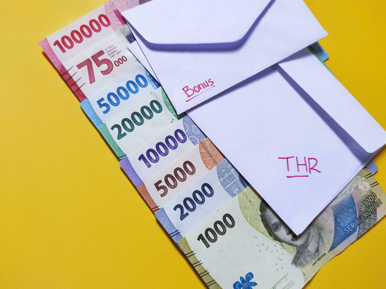 nieuw bankbiljetten uitgegeven in 2022 van rp. 1.000 naar rp. 100.000. Indonesisch roepia valuta met een wit envelop gelabeld thr en bonus. tunjangan hari raya concept foto