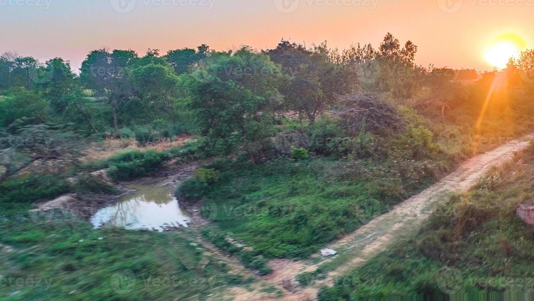 zonsondergang visie van een trein venster in landelijk Indisch dorp foto