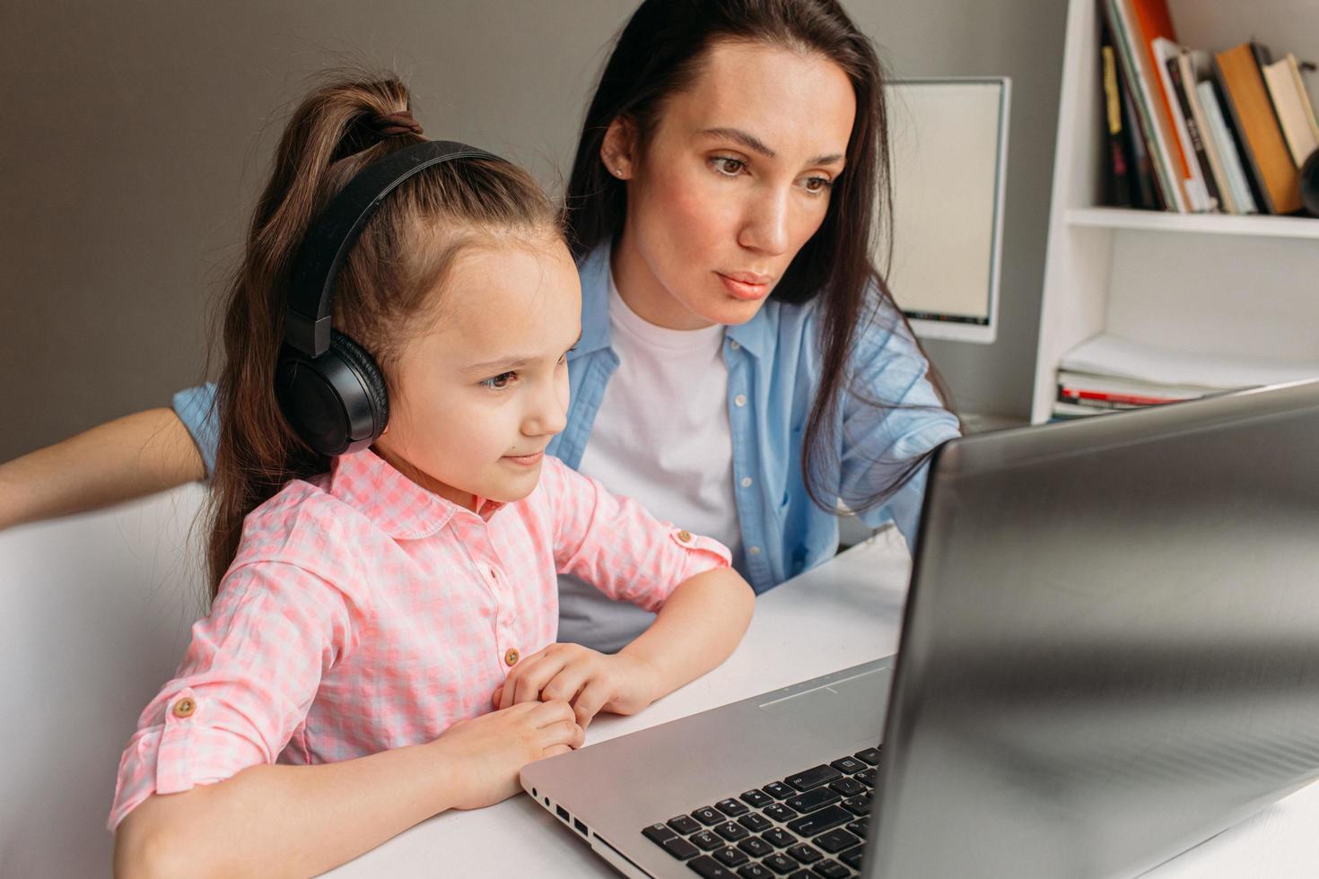 moeder en dochter met behulp van een laptop voor virtuele school foto