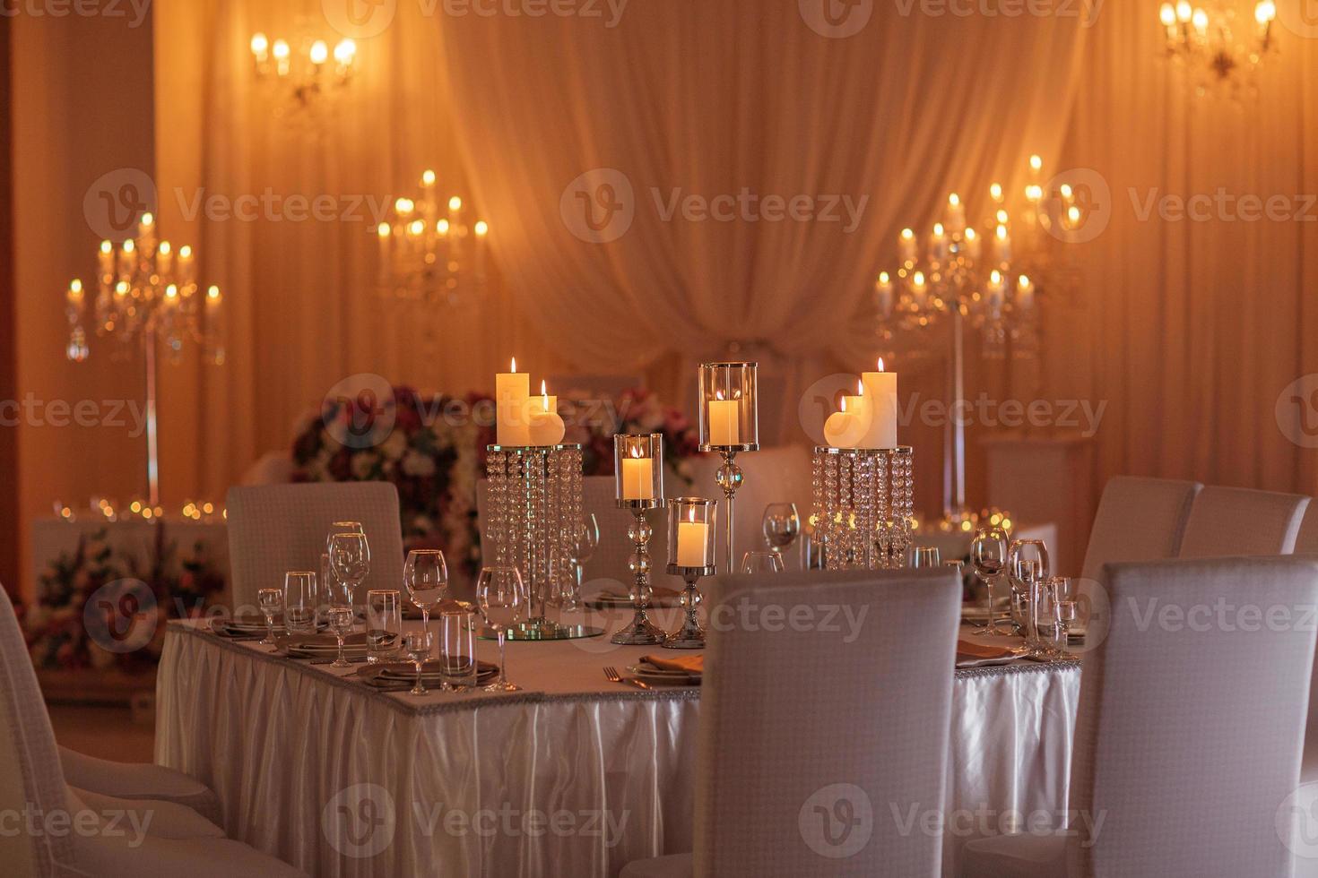 feestelijke tafel versierd met bloemen, doek en kandelaars. luxe huwelijksdecoratie met verlichting. selectieve aandacht. foto