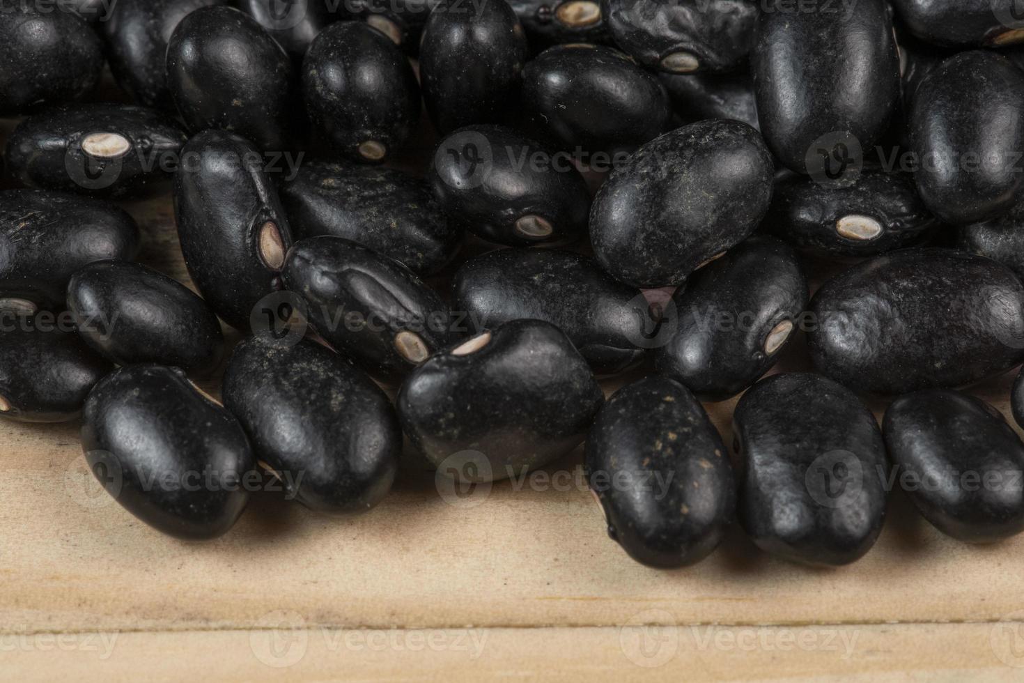 hoop van zwart bonen verspreide over- rustiek hout foto