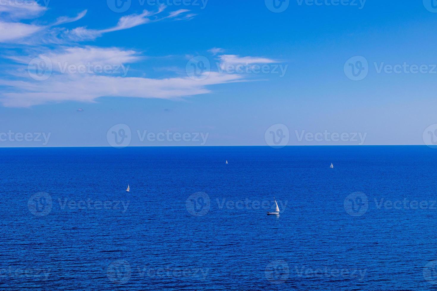 kalmte blauw kust landschap met water en lucht en zeilboten foto