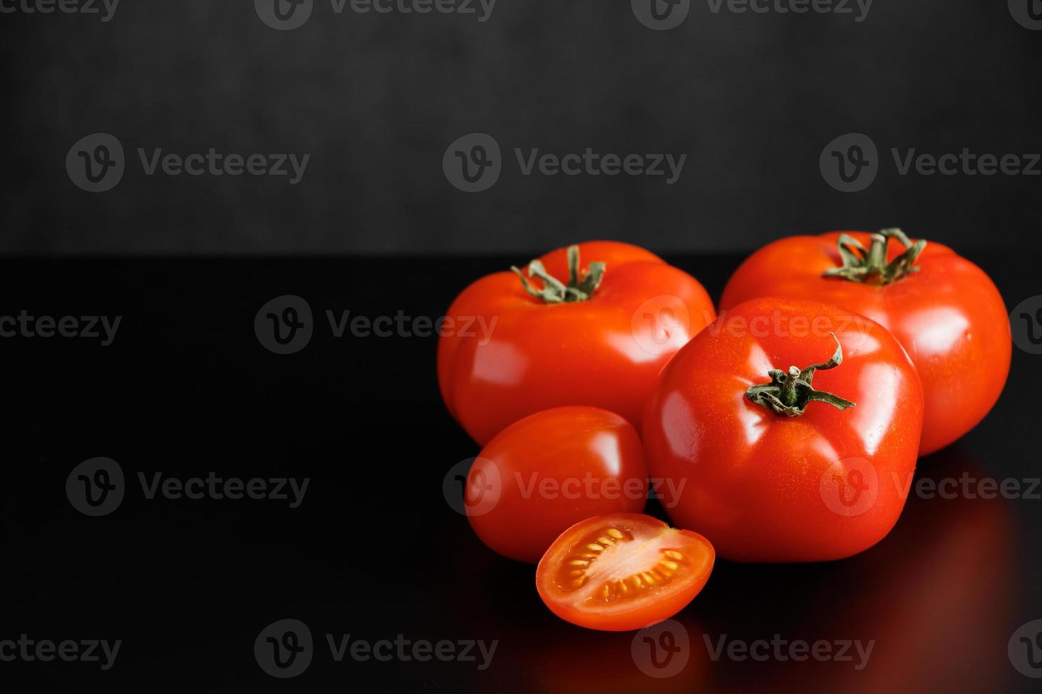 rijpe rode tomaten op een zwarte achtergrond foto