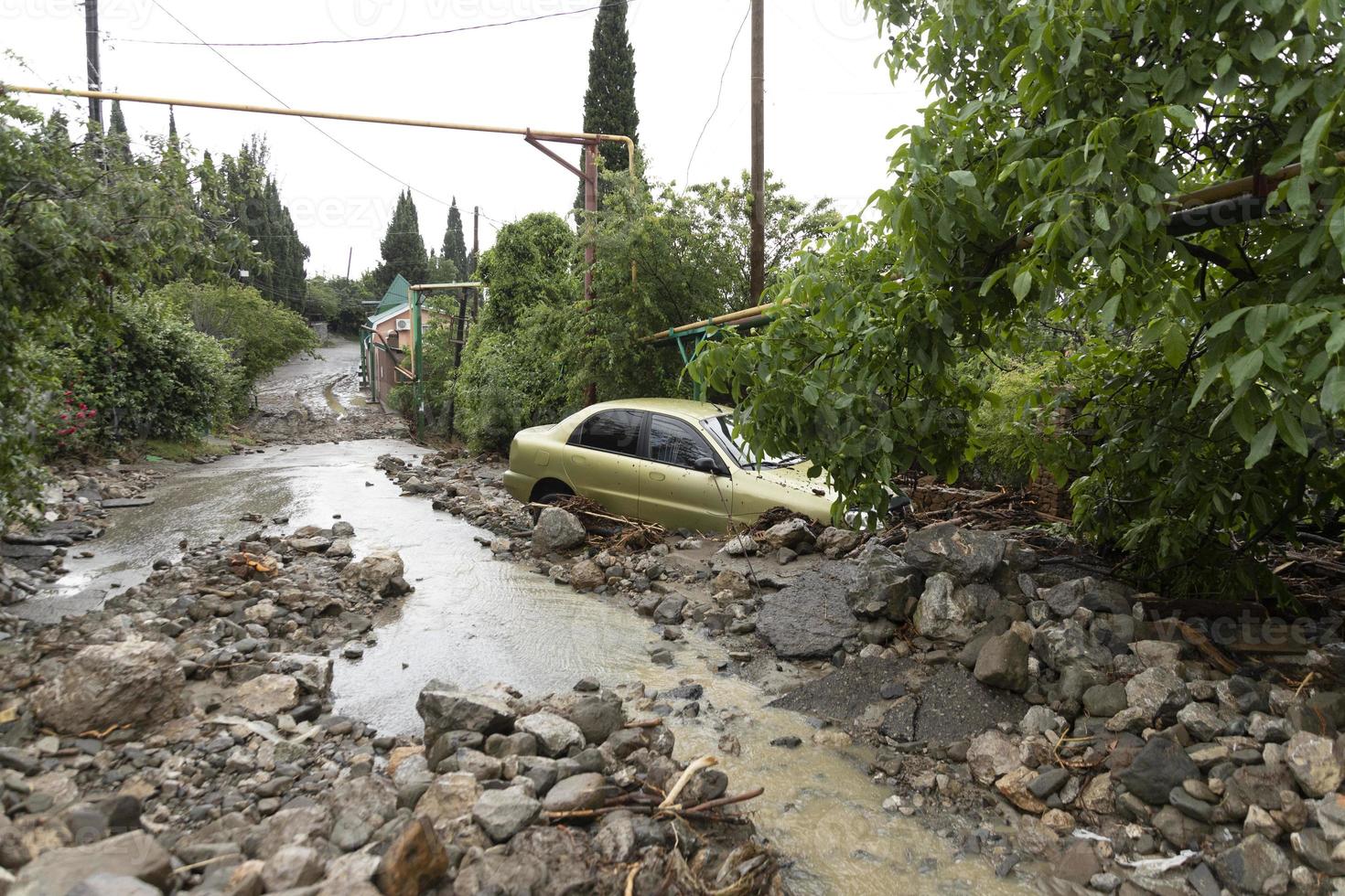 een natuurlijk ramp van overstromingen, modderig streams van water met stenen en modder in de straten van de stad. foto