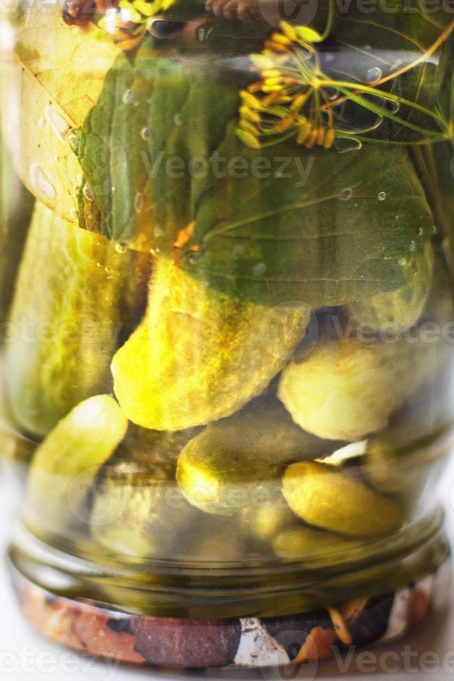 gepekeld komkommers in een glas kan. omgekeerd pot met komkommers. foto