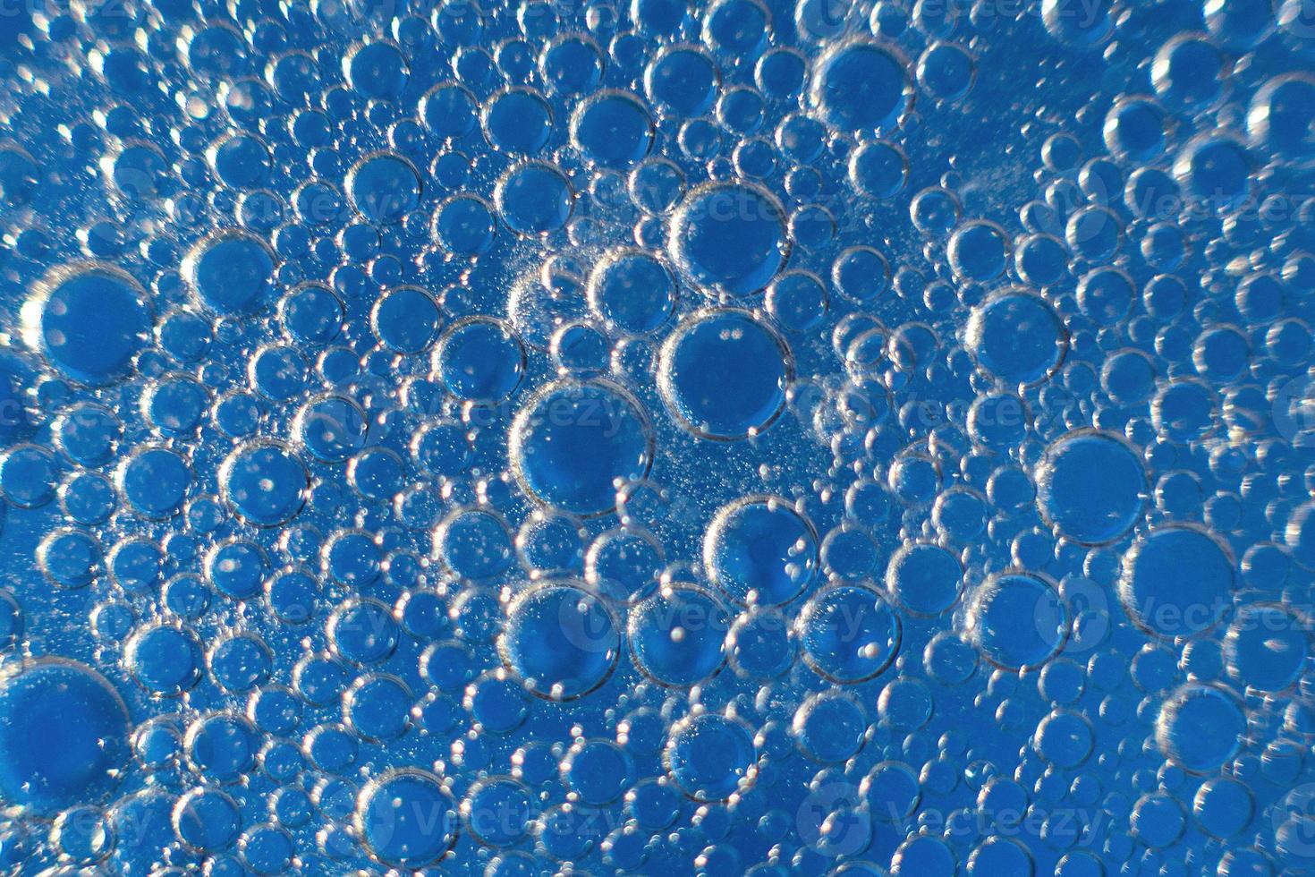 abstract licht blauw achtergrond met olie cirkels . bubbels van water dichtbij omhoog . olie bubbels in de water macro. cirkel bubbels achtergrond foto