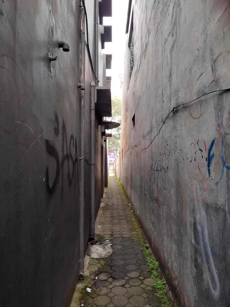 heel versmallen steeg met muren van huizen Aan beide zijden en met bestrating blokken pad foto