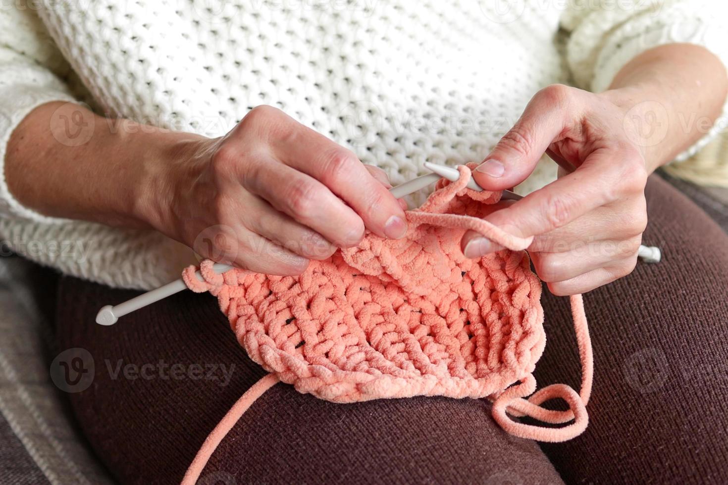 detailopname van vrouwen handen breiwerk een wollen item. handgemaakt kleren. foto